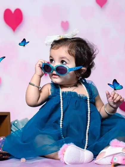 Another stylish shot from the same session, with a dreamy pink background filled with hearts and butterflies.