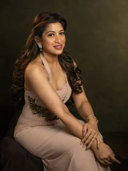 This portrait of Pallavi showcases a bright, confident smile. The lighting is crafted to highlight her features and the elegant lines of her dress, capturing a moment of pure joy and self-celebration during her 40th birthday shoot.