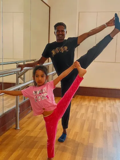 Our coach Chandru strikes a pose with a young gymnast, showing her how to achieve the perfect leg hold.