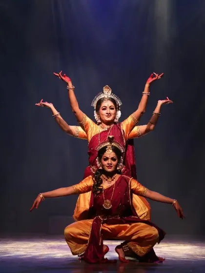 A beautifully synchronized moment from "Shrishti Stithi Laya". The three dancers move as one, their forms highlighted by dramatic spotlights, embodying the principles of creation, preservation, and dissolution.