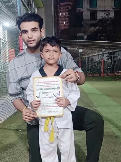 A young student proudly holds his certificate of achievement. Recognizing progress is key to keeping students motivated.