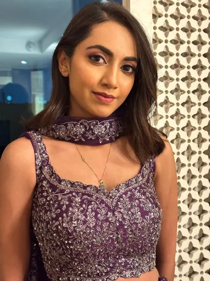 The client looks poised and elegant in her Sangeet attire. The makeup enhances her features while letting her natural beauty shine.