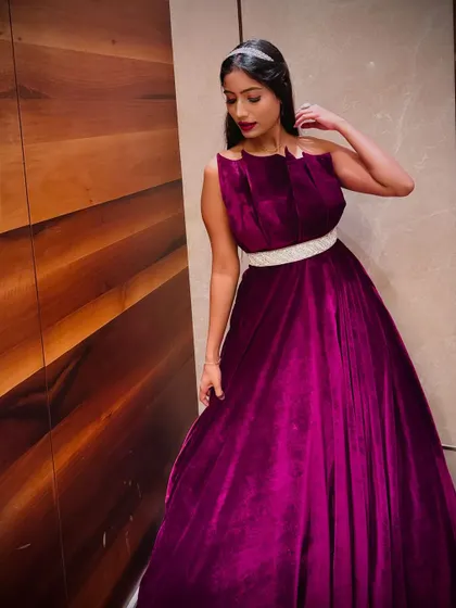 Another angle of the magenta velvet gown, highlighting its elegant pleats and flattering silhouette.