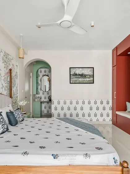 A full view of the master bedroom, showing how the bold burgundy wardrobe, Chinoiserie wallpaper, and compact dressing nook all work together in harmony.