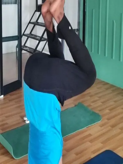 Yes, you can learn headstands in a workshop, even as a beginner. This student is finding their balance in a tucked headstand.