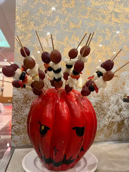 A creative fruit display for a Halloween party. I used a painted pumpkin as a holder for fresh fruit skewers.