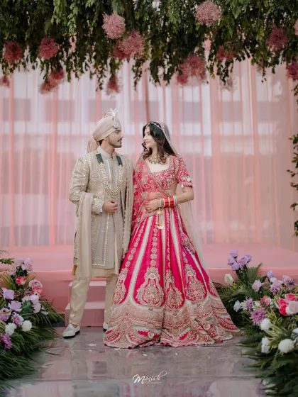 A beautiful portrait of the couple under a canopy of flowers. The stunning decor and their elegant attire come together to create a picture-perfect wedding memory.