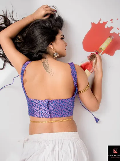 An overhead shot from the 'Nasha' series. The model lies on the floor with a spilled bottle of wine, creating a dramatic and artistic representation of addiction and its aftermath.