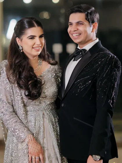 A happy couple at their engagement, with the bride wearing a beautiful half-up style.