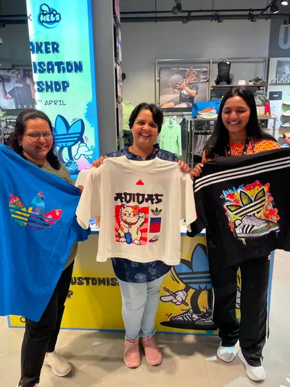 A group of friends and family proudly displaying their new custom-printed t-shirts. Our live apparel printing is a great activity for group outings.