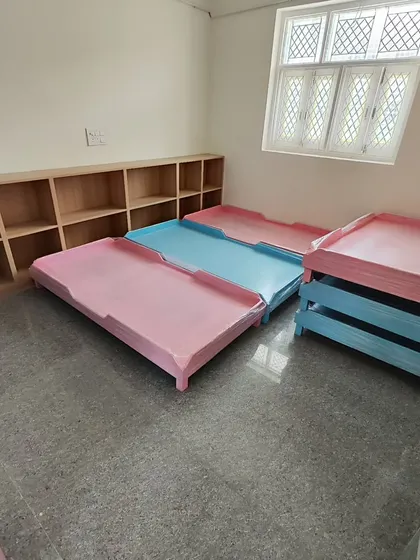 A closer look at the nap cots. Sourcing the right furniture is a key part of a school project, and these were chosen for their safety, durability, and space-saving design.