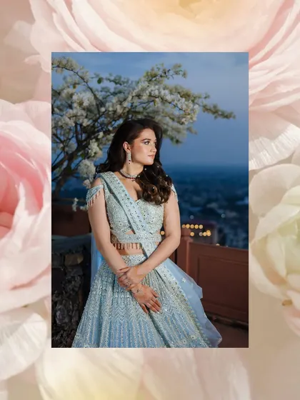An artistic portrait of a bride against a twilight sky, framed by a pink floral border.
