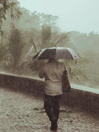 A person walks through a heavy downpour, completely immersed in the monsoon.