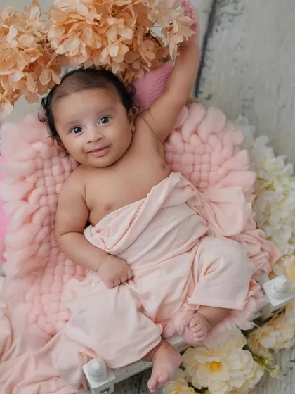 A happy little blossom. This baby is awake and content, enjoying the soft textures and beautiful flowers in her setup.