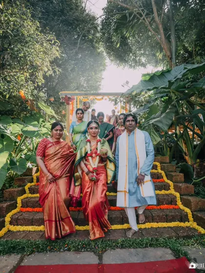 The bride's grand entrance down the flower-adorned steps with her parents.