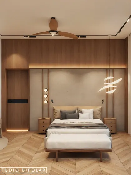 This bedroom design combines a wood-paneled feature wall with a textured headboard and sculptural lighting. The herringbone wood flooring adds another layer of pattern and warmth to the space.