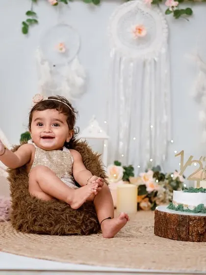 Six months old is the perfect time for a "sitter session". This boho-themed setup with a teepee and dreamcatchers beautifully captures this adorable milestone.