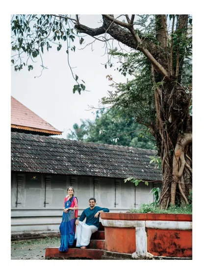 The couple relaxing under a large banyan tree, a classic element in South Indian landscapes. This shot captures a peaceful, candid moment away from the main temple structure.