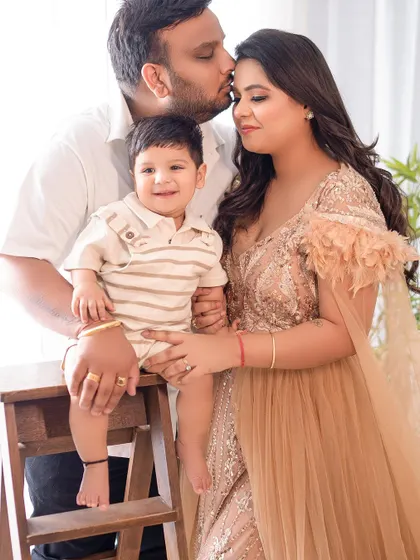 A happy family of three in a tender embrace. The father's kiss on the mother's head shows the love that surrounds their beautiful baby boy.