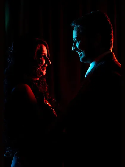 A silhouette of the couple highlighted with red and blue light. This moody and intimate portrait focuses on their profiles and the connection between them.