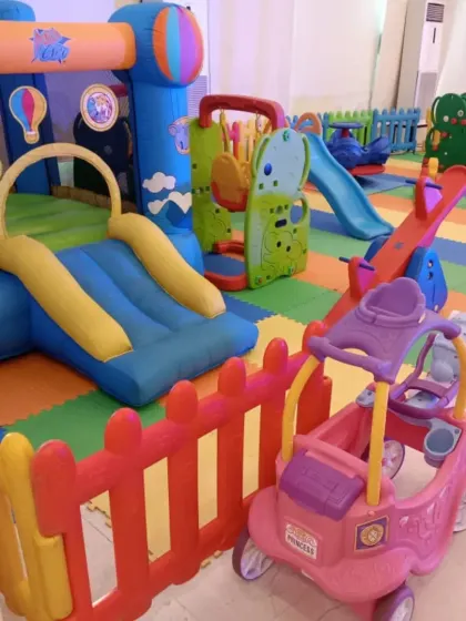 This indoor setup features a large bouncy castle with a slide, a seesaw, and a princess-themed ride-on cart. It’s a perfect combination for a birthday party, offering both active and imaginative play options.