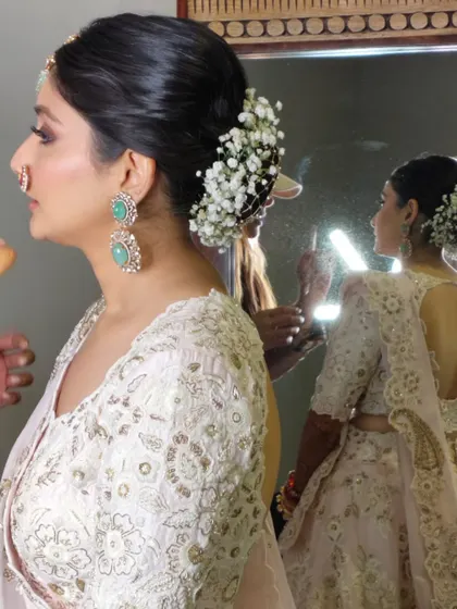 A profile view of the bride with her baby's breath bun, showing how it pairs with her elegant jewellery and outfit.