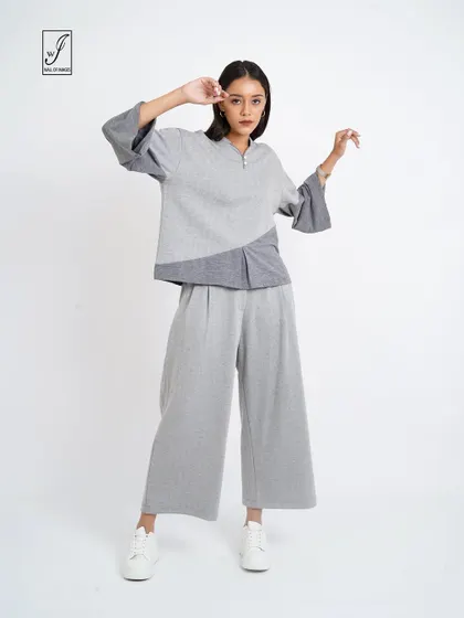 A grey color-blocked lounge set, posed to show the relaxed fit and unique design.