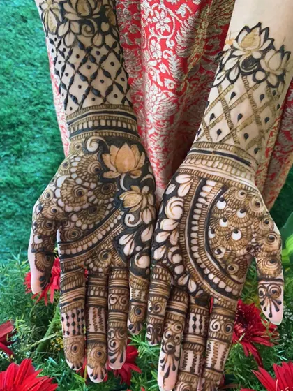 A different pose showcasing the back of the hands, with detailed lotus designs on the wrists.