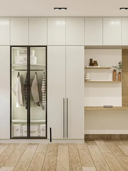 A sleek, floor-to-ceiling wardrobe in white acrylic finish with a glass-fronted section and an integrated study nook.