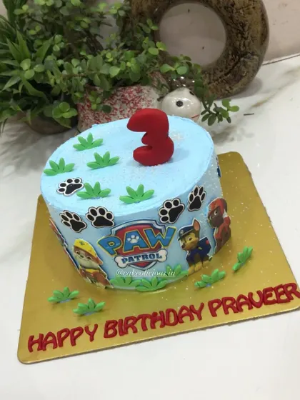 A Paw Patrol themed cake for a 3rd birthday celebration. This simple yet fun whipped cream cake is decorated with the Paw Patrol logo, characters, and paw prints.
