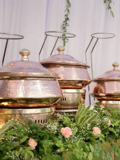 Our serveware is chosen to enhance the dining experience. This close-up shows our hammered copper chafing dishes, which not only keep food at the perfect temperature but also add a touch of traditional luxury to the buffet presentation.