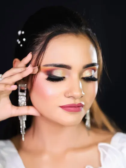 The eyes-closed pose beautifully displays the soft, blended eyeshadow, a key technique for achieving a professional finish.