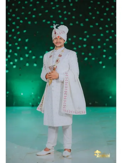 A full-length portrait of the groom, looking elegant and ready for his wedding.