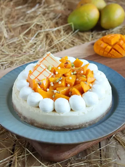 Satisfy your sweet tooth with our baked fresh mango cheesecake. Topped with fresh mango chunks and pistachio slivers, it's a creamy, decadent dessert perfect for beating the heat.