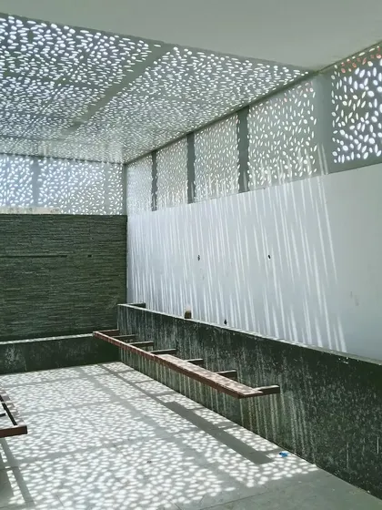 A work-in-progress shot of the lower terrace, showing the raw structure and the beautiful patterns created by the perforated roof. This demonstrates how the core concept of light and shadow was planned from the early stages.
