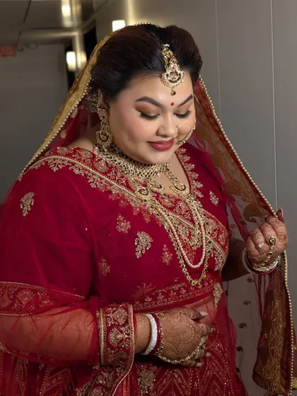 A full view of the bride in her magnificent red lehenga, exuding grace and happiness.