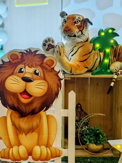 A close-up of a friendly lion cutout and a plush tiger prop.