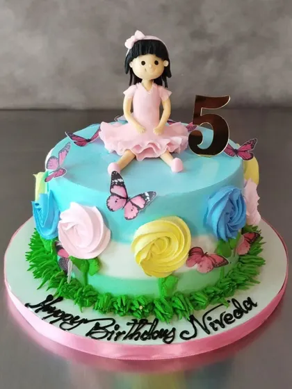 A lovely butterfly garden cake for Niveda's 5th birthday. The cake features a custom doll topper, colorful buttercream roses, and delicate edible butterflies.