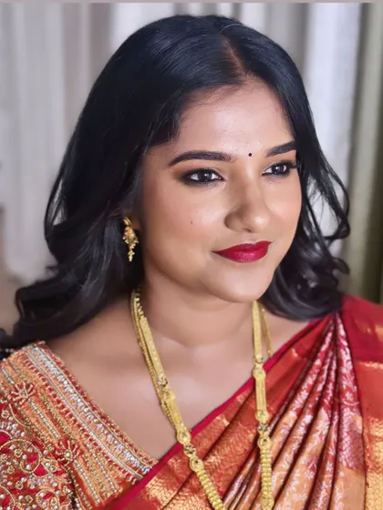 Keerthana chose a classic look for her reception with a bold red lip and soft waves, pairing beautifully with her red Kanjivaram saree.
