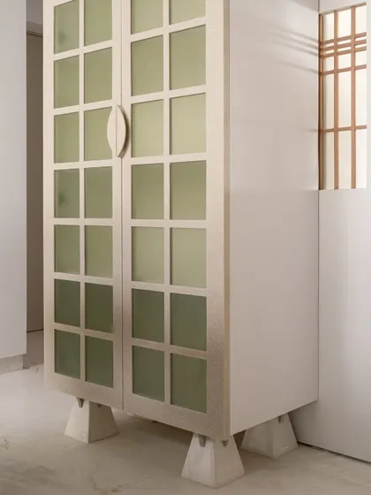 The kitchen in our Gingham Dreams project is a 'snowy wonderland' of quartzite and pristine white cabinetry. A full-height crockery almirah borrows details from the Japanese-style ceiling light.