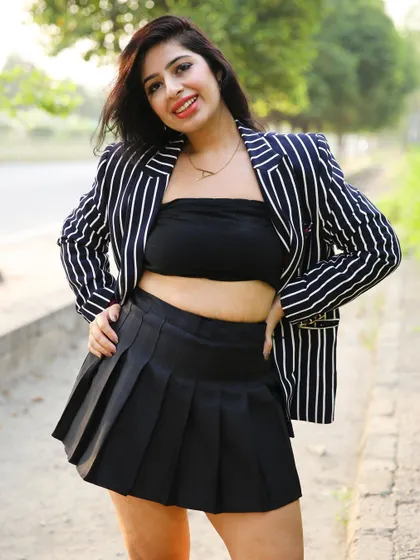 A full-look shot that displays the entire outfit, including the pleated skirt and bandeau top.