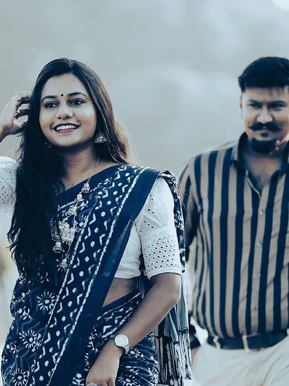 A duplicate of a candid walking shot of a couple in traditional attire, with the bride in focus, set against a blurred city street.