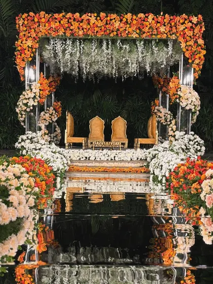 A closer look at the floating mandap at night, where the combination of flowers and mirrored pillars creates a magical, glowing effect.