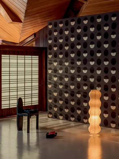 The 'Royal Emblème' wallcovering from Élitis, featuring a harmonious blend of gold hues and matte paper. The repeating half-moon pattern creates a symphony of light and shadow in this Japanese-inspired interior.