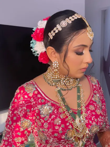 A side view of the bride, showing the colorful floral arrangement in her bun.