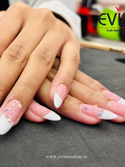 You can never go wrong with a classic French manicure. Here, I've given it a modern twist with a soft pink base, crisp white tips on almond-shaped extensions, and a few carefully placed rhinestones for a touch of sparkle.