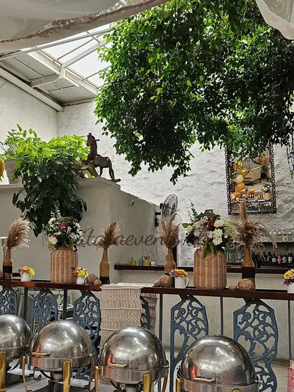 The buffet setup at a boho-themed 30th birthday party at Olive Bar and Kitchen. The rustic decor with pampas grass and woven vases complements the restaurant's natural ambiance.