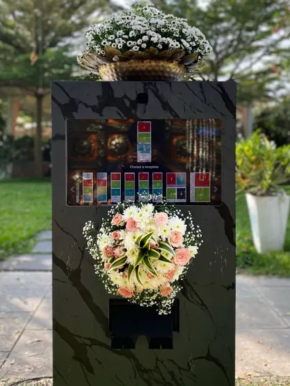 My photobooth is designed to be a beautiful addition to your decor. This black marble-finish booth, styled with a lush floral arrangement, added a touch of elegance to a gorgeous outdoor wedding. I can customize the look to perfectly match your event's aesthetic.