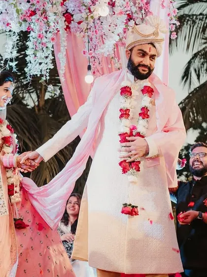 The couple takes their pheras, walking around the sacred fire, with guests showering them with petals.