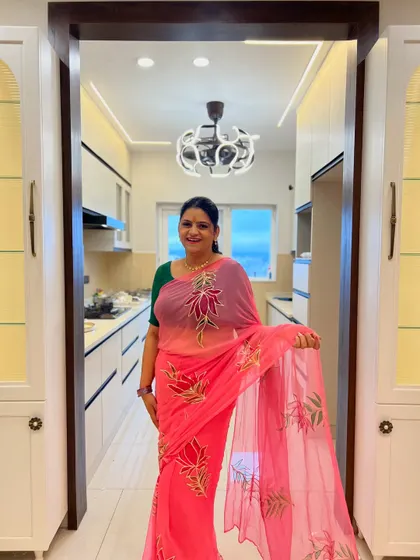 A happy client in her brand new, fully functional kitchen. The design features sleek white cabinets, integrated lighting, and a layout that makes cooking a joyous experience.